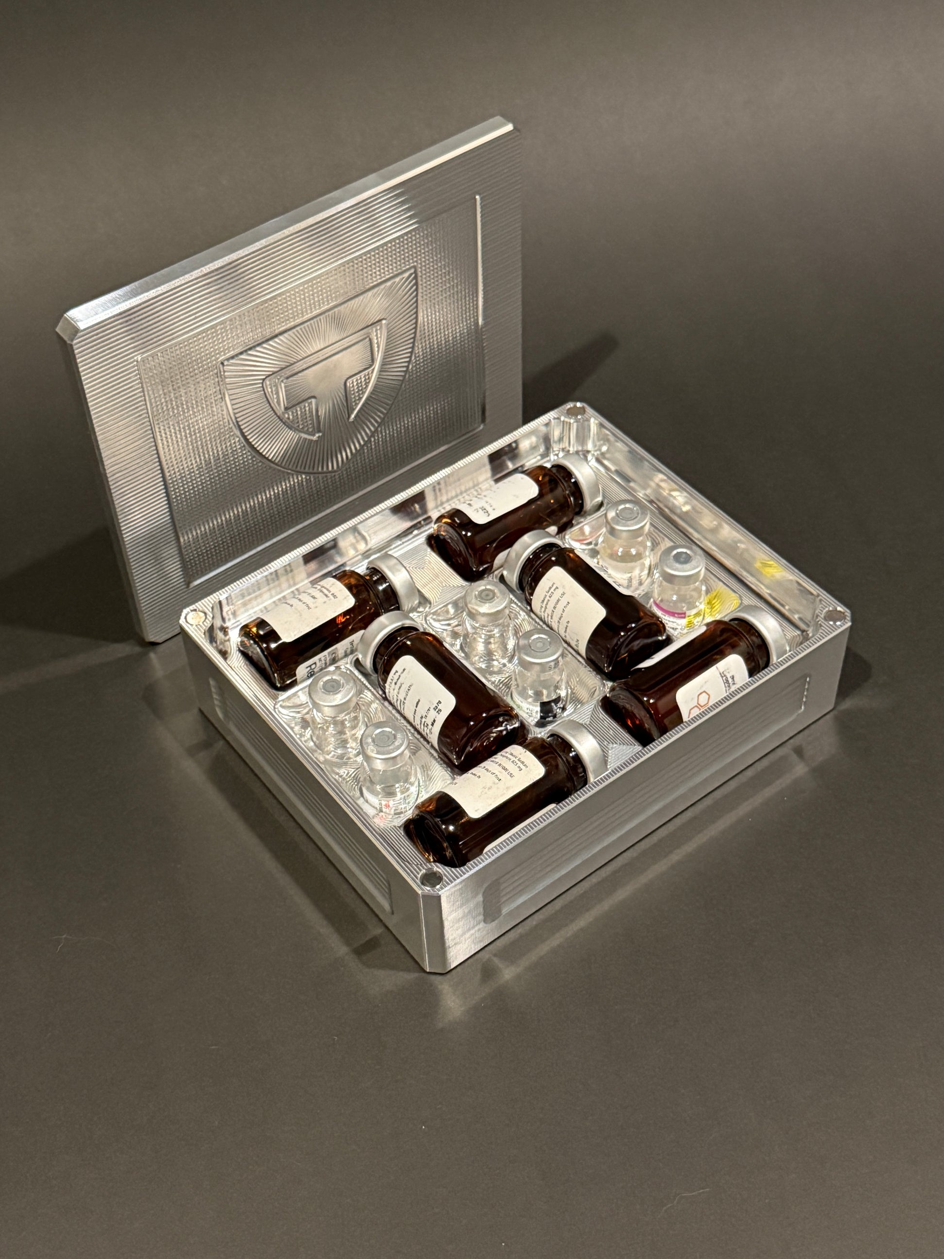 Raw machined aluminum Peptide Vault Mini shown open and loaded with large and small peptide vials.