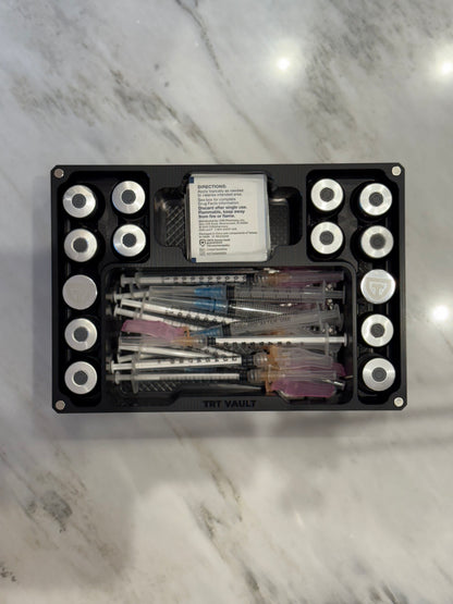 Overhead view of an Anodized Black Cycle Vault Mega showing upright vial slots and compartments filled with syringes and alcohol swabs.