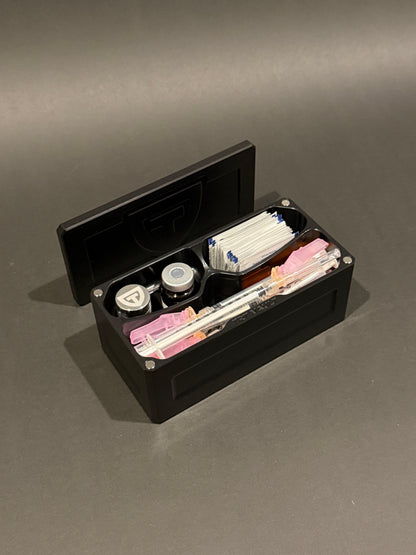 Open Cycle Vault Micro in Anodized Black holding a vial, the included pill vial, syringes and alcohol swabs.
