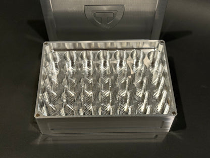 Overhead close-up of raw machined Vial Vault Mega shown open and empty with precision-machined vial storage slots and magnetic lid behind it.