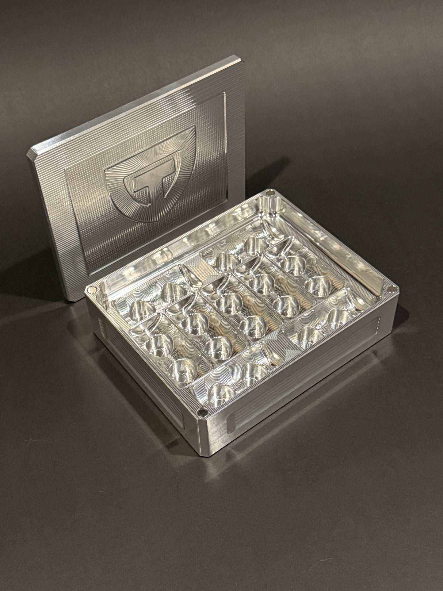 Raw machined aluminum Peptide Vault Mini shown open and empty, displaying nine vial storage slots.