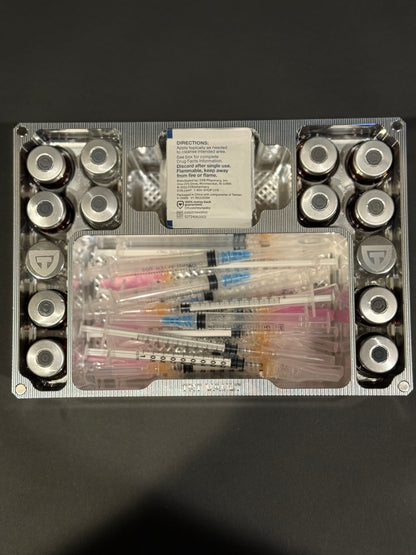 Overhead view of a Raw Machined Cycle Vault Mega showing upright vial slots and compartments filled with syringes and alcohol swabs.