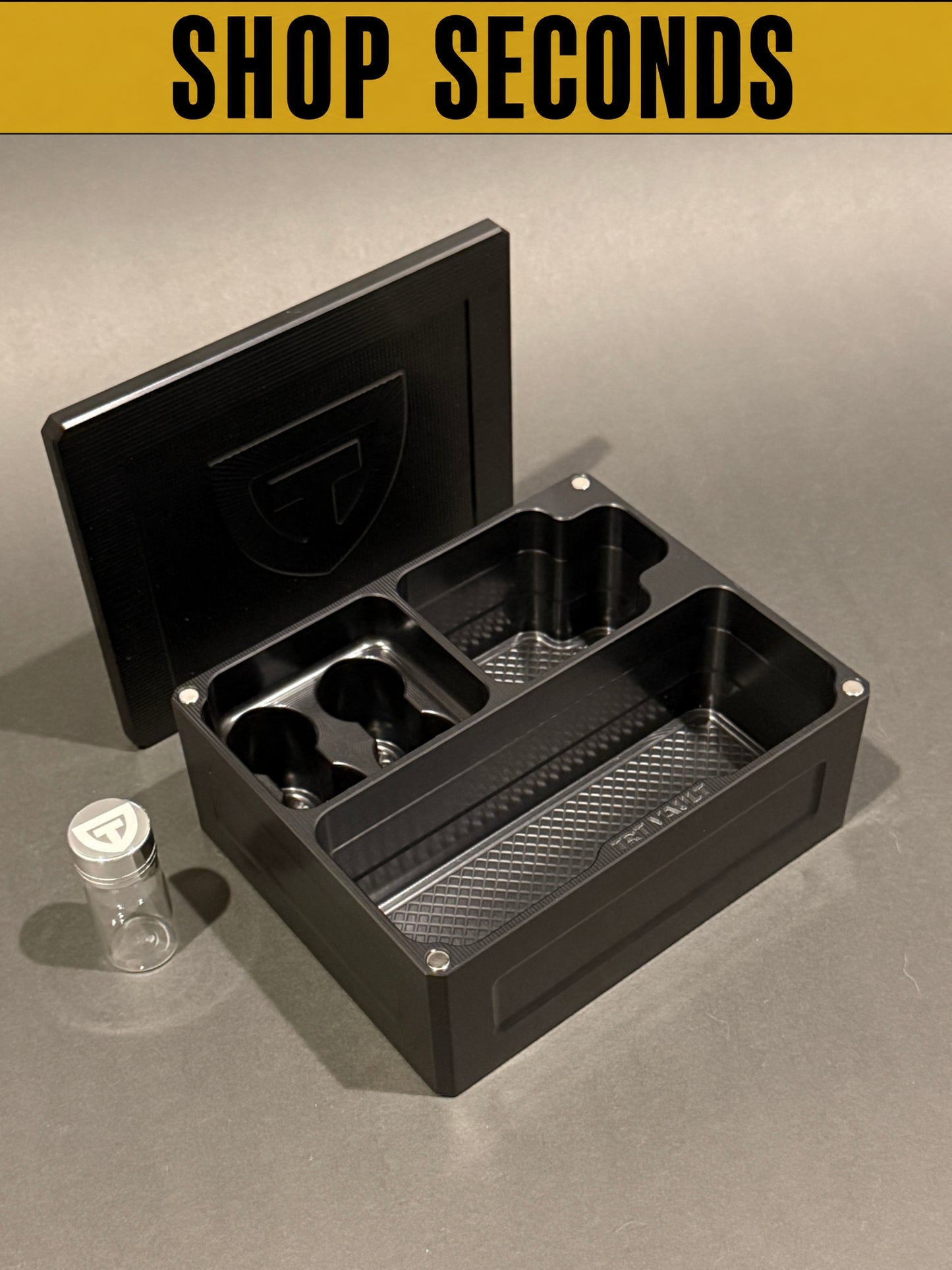 Shop Seconds black anodized Cycle Vault Mini shown open with magnetic lid and one sample vial, displaying upright vial slots and supply compartments.
