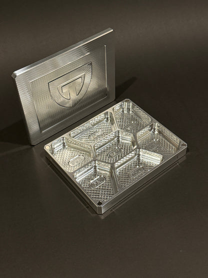 Open raw machined Vitamin Vault Mini with its magnetic lid and seven empty labeled daily compartments.