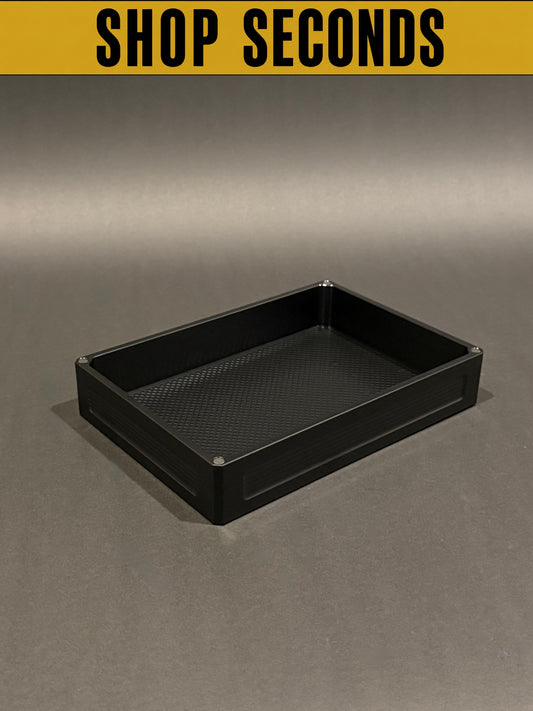 Flex Vault Mega Lidless in anodized black, Shop Seconds condition, shown empty on a gray surface.