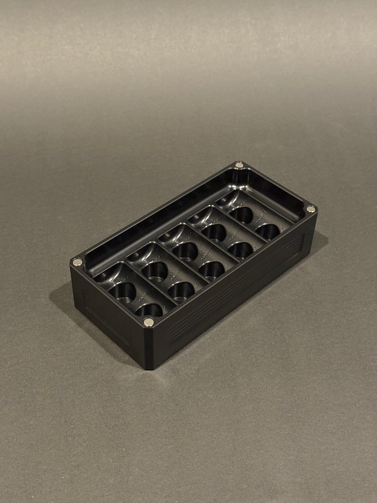 Anodized Black Peptide Vault Micro Lidless shown empty with precision-machined vial storage slots.