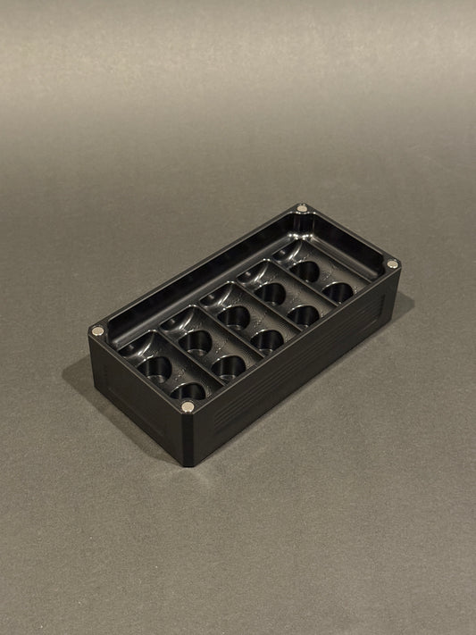 Anodized Black Peptide Vault Micro Lidless shown empty with precision-machined vial storage slots.