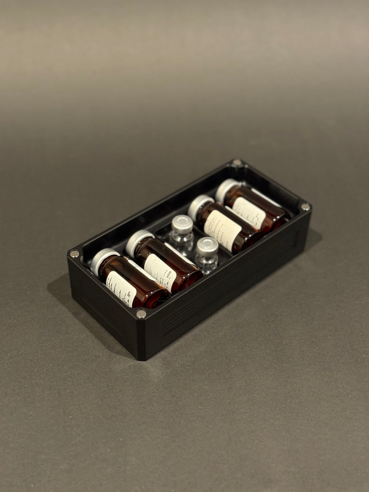 Anodized Black Peptide Vault Micro Lidless shown filled with assorted peptide vials.