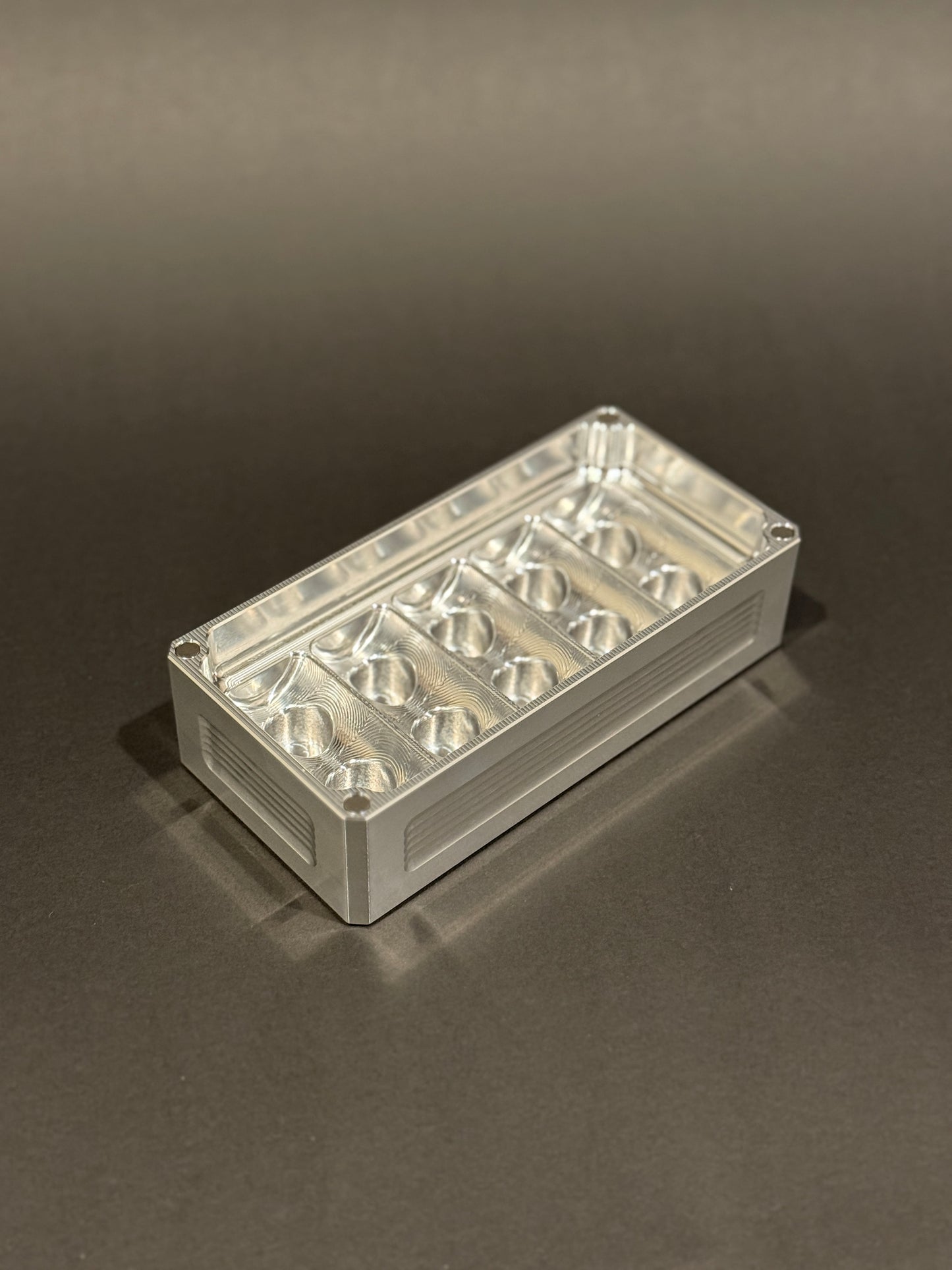 Raw machined Peptide Vault Micro Lidless shown empty with precision-machined vial storage slots.