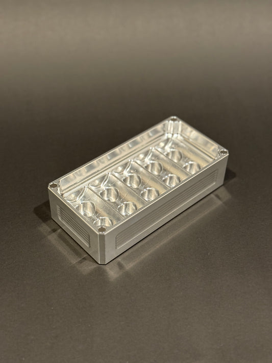 Raw machined Peptide Vault Micro Lidless shown empty with precision-machined vial storage slots.