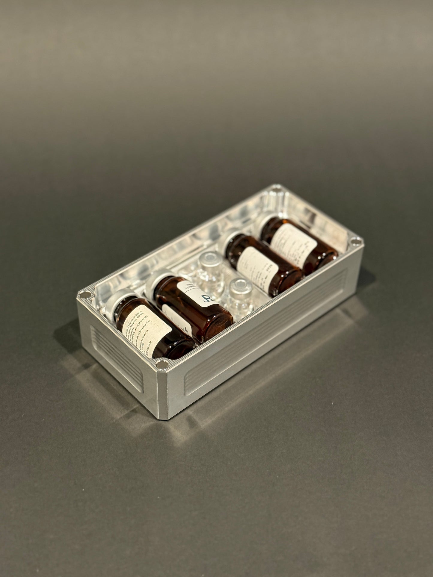 Raw machined Peptide Vault Micro Lidless shown filled with assorted peptide vials.