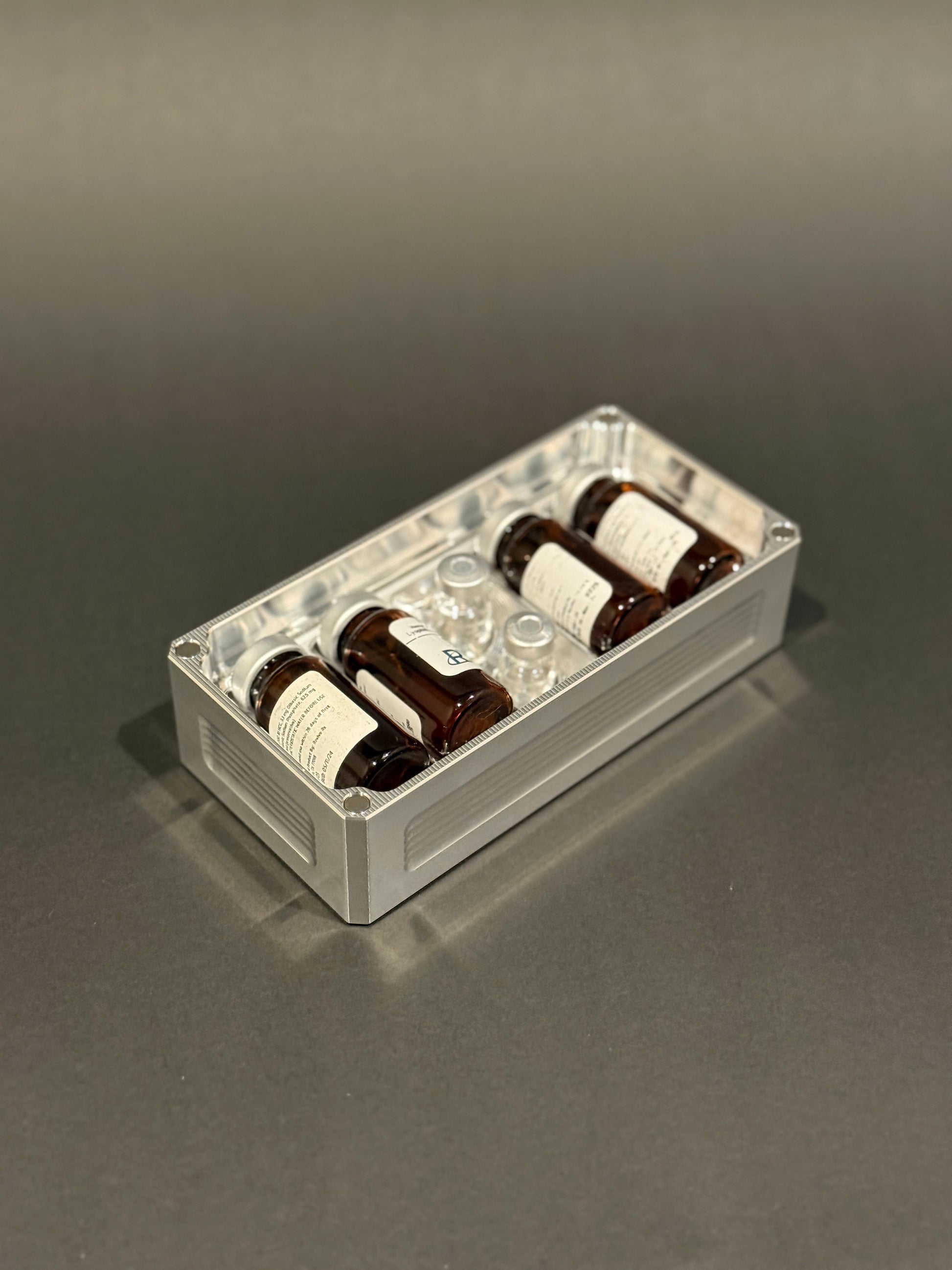 Raw machined Peptide Vault Micro Lidless shown filled with assorted peptide vials.