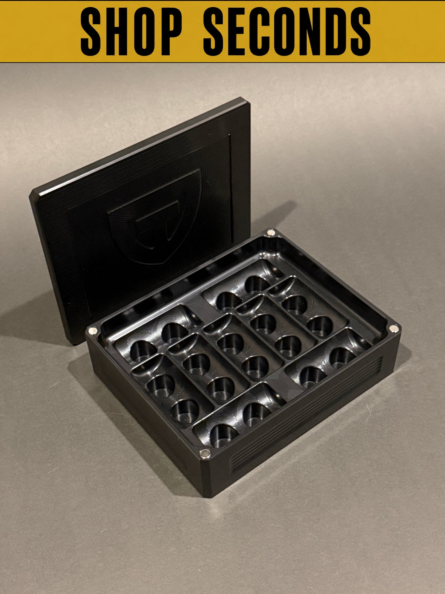 Shop Seconds black anodized Peptide Vault Mini shown open and empty with magnetic lid, displaying vial storage slots.
