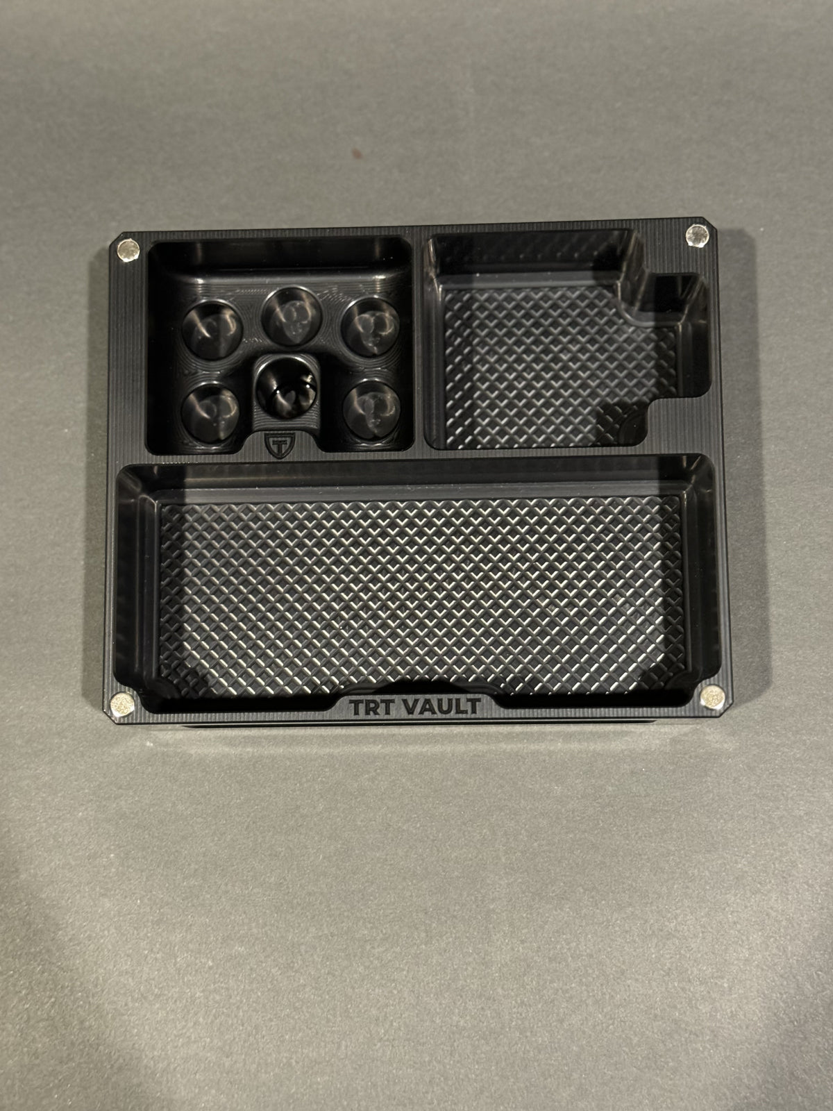 Empty TRT Vault Mini in Anodized Black shown from above with vial and syringe compartments visible.