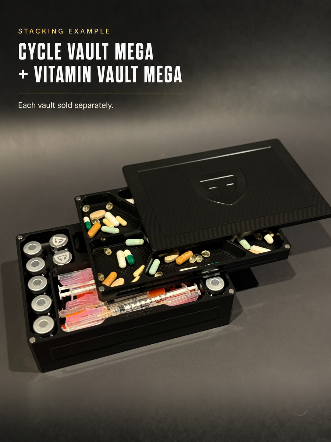 Open Black Anodized Cycle Vault Mega with vials and syringes stacked beneath a Vitamin Vault Mega with capsules; each vault sold separately