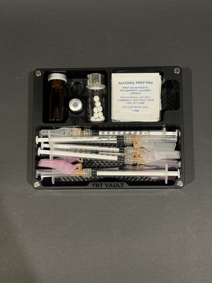 Open TRT Vault Mini in Anodized Black holding vials, syringes, alcohol swabs and pill vial.