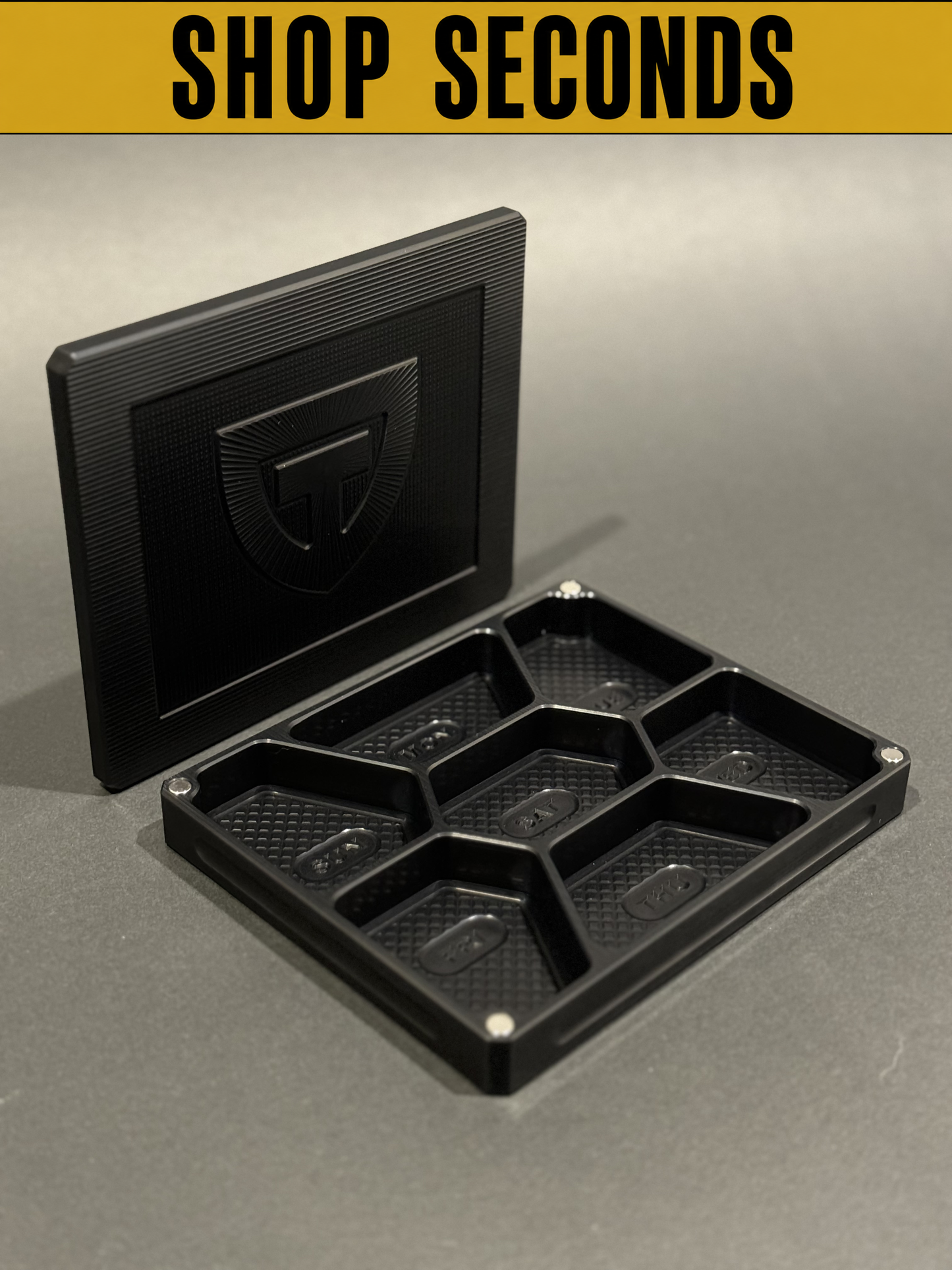 Shop Seconds black Vitamin Vault Mini shown open and empty with divided storage compartments and lid.