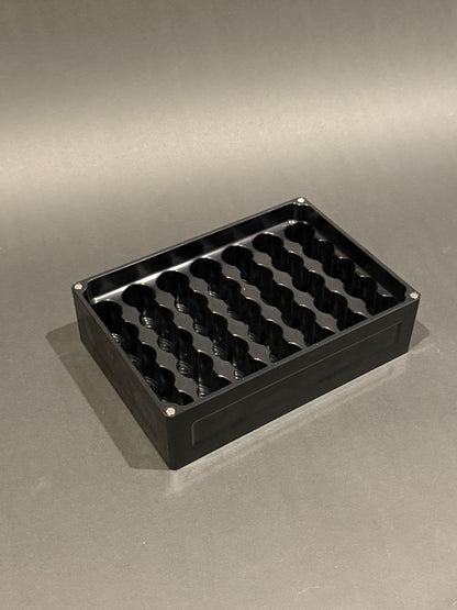 Lidless Vial Vault Mega in Anodized Black, shown empty with precision-machined upright vial storage slots.