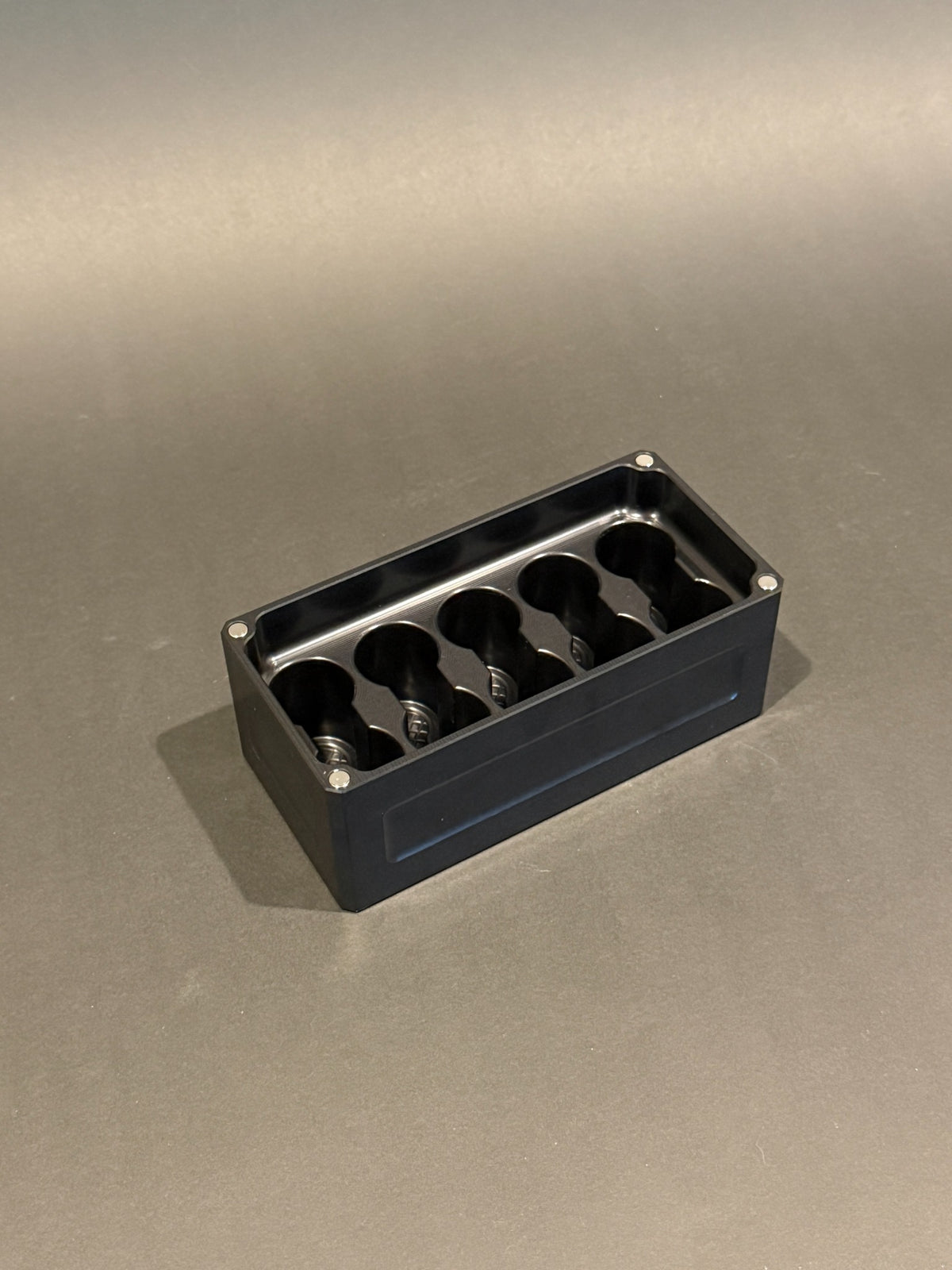 Lidless Vial Vault Micro in Anodized Black, shown empty with precision-machined upright vial storage slots.