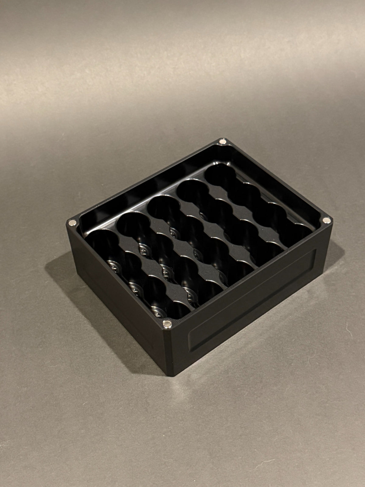Lidless Vial Vault Mini in Anodized Black, shown empty with precision-machined upright vial storage slots.